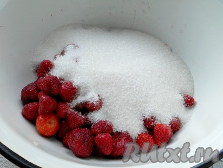Клубнику поместить в дуршлаг, хорошо промыть под проточной водой. Удалить хвостики. Поместить ягоды в глубокую миску, засыпать сахаром.
