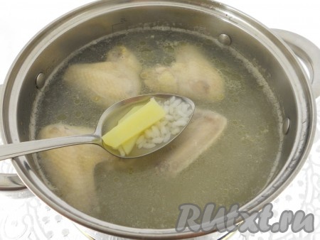 Куриные крылышки поместить в кастрюлю, залить водой и поставить на огонь. Довести до кипения, снять пену, посолить по вкусу. Варить крылышки на медленном огне 10 минут, после чего добавить в кастрюлю картофель и промытый рис.