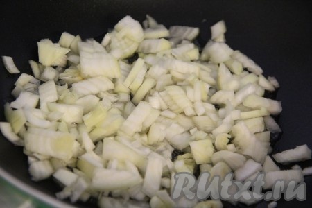 Лук очистить. Лисички очистить, вымыть. На сковороде разогреть растительное масло, выложить лук, нарезанный на мелкие кубики, и обжарить его, периодически помешивая, до золотистого цвета (в течение 5-6 минут) на среднем огне.