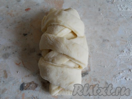 Завернуть полосочки теста крест-накрест на начинку, формируя пирожок с клубникой. Края полосок защипнуть под нижней частью пирожка.