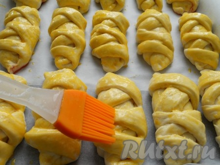 Таким образом сформировать остальные пирожки с клубничной начинкой, выложить их на расстоянии друг от друга на противень, застеленный пергаментом. Оставить пирожки с клубникой на 20 минут для расстойки дрожжевого теста. Отложенные ранее желтки взболтать. Смазать взбитыми желтками поверхность пирожков.
