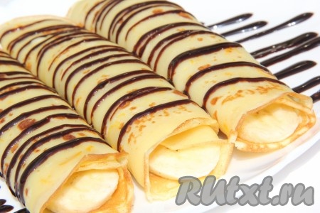 Блинчики с бананом можно полить шоколадным сиропом и украсить свежей клубничкой (или другими ягодами). Обязательно приготовьте эти прекрасные блины, замешанные на молоке без добавления соды и разрыхлителя, а подавать их с фруктами или без - это дело вкуса.
