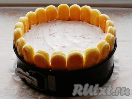 Слой крема равномерно выложить поверх застывшего мусса. Торт, приготовленный из савоярди с маскарпоне, клубникой и сливками, убрать в холодильник до полного застывания всех слоёв (желательно на ночь). 