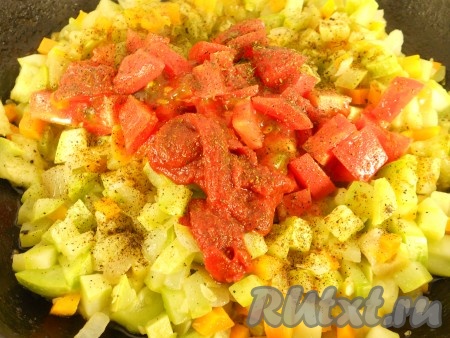 Помидоры также порезать кубиками и добавить к остальным овощам вместе с томатной пастой. Посолить, поперчить и посыпать специями. Влить немного воды, овощи перемешать и тушить на слабом огне минут 7-8.&nbsp;