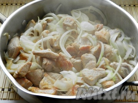 Выложить лук в сковороду к мясу, перемешать и обжарить, иногда помешивая, до зарумянивания лука.