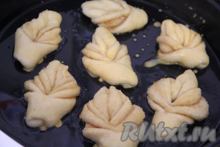 Подготовленные красивые плюшки из дрожжевого теста выложить на небольшом расстоянии друг от друга на смазанный растительным маслом противень, дать булочкам минут 20 отдохнуть. Яичный желток выложить в небольшую ёмкость, добавить 1 столовую ложку молока, взбить вилкой до однородности. Смазать верх плюшек смесью из взбитого желтка с молоком.