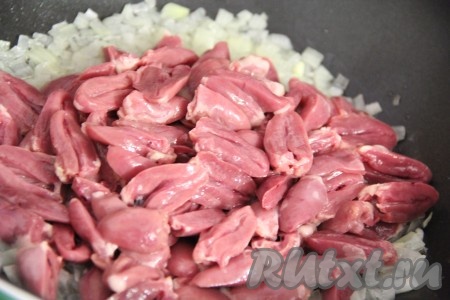 Сердечки разрезать пополам и выложить к луку на сковороду.