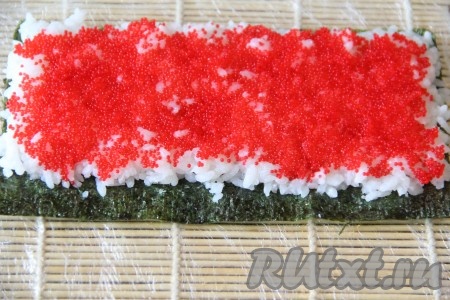 Затем выложить слой икры летучей рыбы.