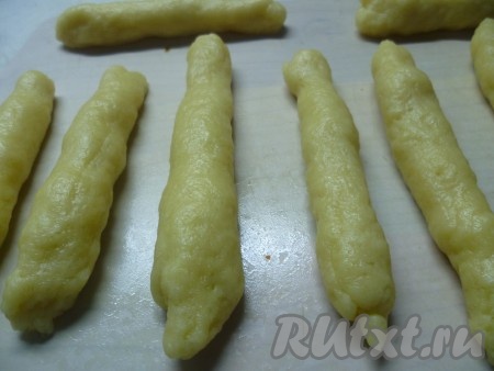 Сформировать из теста палочки, зауженные по краям, длиной примерно 10 см и толщиной - 1 см.
