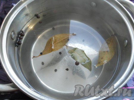 Затем аккуратно воду из банки слить в раковину. Снова влить в банку кипящую воду, полностью покрывая овощи, прикрыть крышкой, оставить на 8 минут. В это же время влить в кастрюлю 1,5 литра воды, добавить соль, сахар, горошины чёрного и душистого перцев, лавровые листья, перемешать, поставить на сильный огонь, после закипания варить на небольшом огне 2-3 минуты (соль и сахар должны полностью раствориться). Затем влить уксус, довести маринад до кипения и снять с огня.