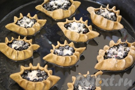 Выложить получившиеся ржаные калитки на противень, предварительно смазанный растительным маслом. Ягоды по желанию можно присыпать сахаром. Поставить противень с пирожками в разогретую духовку и выпекать примерно 15 минут при температуре 180-200 градусов.
