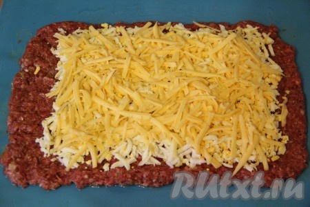  Затем посыпать поверх яиц тёртым сыром.