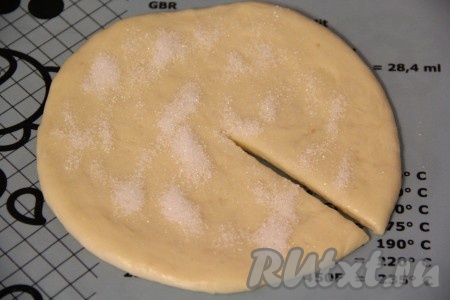 Каждую часть теста раскатать в круглую не тонкую лепёшку, присыпать её сахаром и сделать один разрез от центра до края.