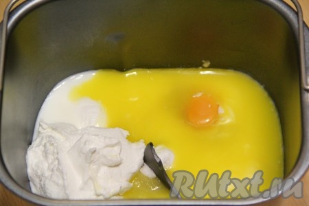 Сливочное масло предварительно растопить до жидкого состояния. Масло должно быть жидким и тёплым, но ни в коем случае не горячим. Это важно! В ведёрко хлебопечки влить кефир комнатной температуры, добавить сырое яйцо и растопленное масло. Затем всыпать сахар и добавить творог.