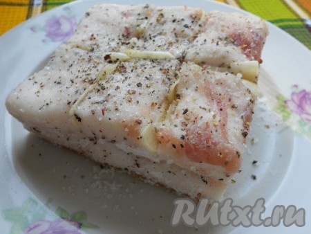 Чеснок порезать тонкими пластинами или кусочками и вложить его в разрезы.
