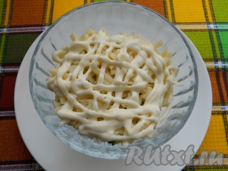 Сверху разложить натёртый на крупной тёрке твёрдый сыр, нанести сеточку из майонеза.