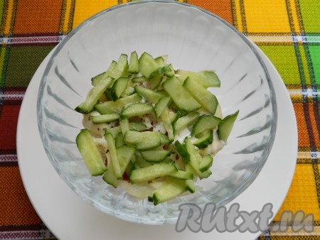 Следующим слоем нужно выложить свежий огурчик, нарезанный на тонкие четвертины (или соломкой), чуть посолить.