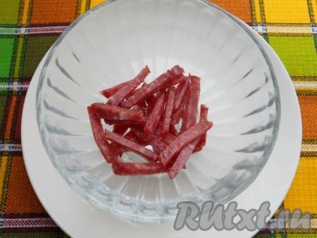 Из болгарского перца удалить семена, очистить чеснок. На дно креманки (или салатника) будем выкладывать салат слоями. Первым слоем нужно выложить копчёную колбасу, нарезанную соломкой.