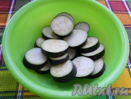 Баклажаны, нарезанные кружочками толщиной около 1 см, щедро посолить, перемешать и оставить на 30 минут.
