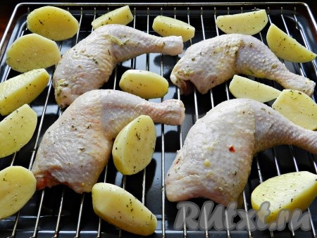 Картофель очистить, разрезать на половинки или четвертинки, смазать оставшейся масляной смесью каждый кусочек и выложить на противень вместе с куриными ножками. Поставить в разогретую до 200 градусов духовку на 45-50 минут. В процессе запекания ножки и кусочки картофеля перевернуть 1-2 раза для равномерного прожаривания. В конце приготовления включить режим "гриль" на 5-7 минут.
