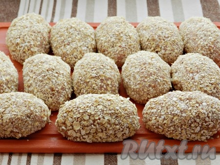 Из фарша сформировать котлеты (у меня получилось 13 штук), обвалять их со всех сторон в овсяных хлопьях (или в муке), выложить на доску и убрать в холодильник на 30 минут.