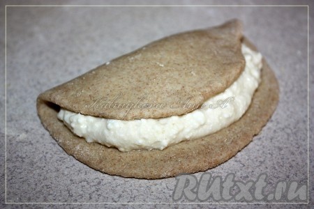 Раскатать тесто толщиной 0,3 см, вырезать круги. На половину каждого кружка выложить творожную начинку и накрыть второй половинкой круга.
