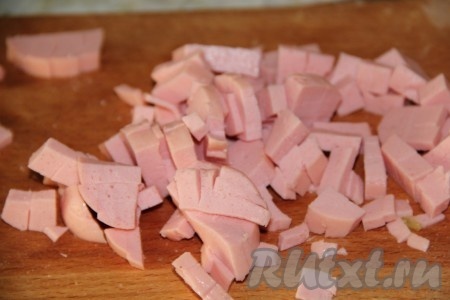 С вареной колбасы снимаем шкурку и измельчаем.