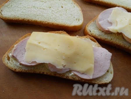 На колбасу поместить тонкий ломтик твердого сыра.
