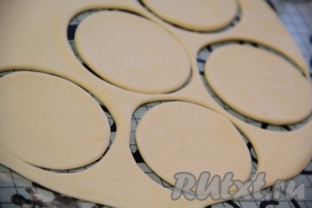 Раскатать тесто скалкой в тонкий пласт. Вырезать кружочки с помощью тонкого стакана.
