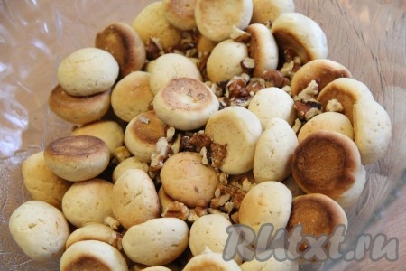 В глубокую миску выложить остывшие шарики из теста, добавить орехи. Я предварительно поломала ядра грецкого ореха на кусочки. 