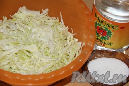 Молодую капусту нарезать на тонкие полоски, выложить в глубокую миску и хорошо помять руками. Капуста должна дать сок. Затем добавить соль, чёрный молотый перец, уксус, хорошо перемешать ложкой. Накрыть миску с капустой крышкой и оставить на 20-30 минут при комнатной температуре.&nbsp;