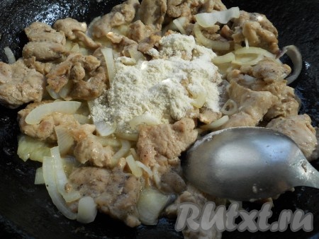 К свинине, обжаренной с луком, всыпать муку и хорошо перемешать.