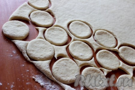 На столе, присыпанном мукой, раскатать тесто в тонкий пласт. Вырезать кружочки с помощью стакана или небольшой кружки.
