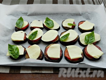 Сверху помидоры накрыть кусочками сыра, добавить несколько листиков базилика и поставить под гриль, разогретый до 200 градусов, на 5-7 минут, чтобы расплавился сыр.
