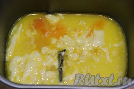  Масло растопить и слегка остудить. В ведёрко хлебопечки влить растопленное масло и желтки. 