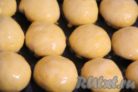 Подошедшие булочки смазать смесью из желтка и молока. Поставить в разогретую духовку и выпекать при 200 градусах примерно 25 минут, до золотистого цвета.
