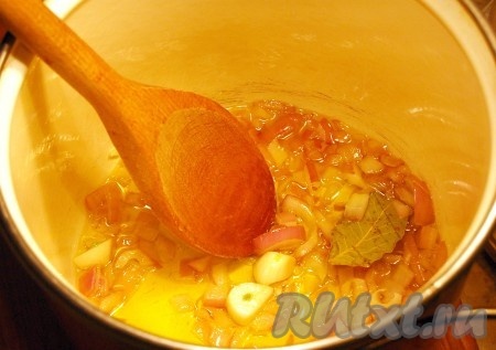 А теперь приступим к варке нашего супа с капустой и колбасой. В кастрюлю с толстым дном налить оливковое (или другое растительное) масло, выложить нарезанные лук с чесноком, лавровый лист, обжаривать минут 5 (до лёгкого чесночного запаха) на среднем огне, помешивая.