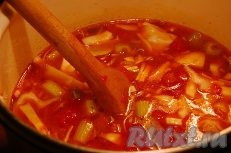 По прошествии времени выложить в кастрюлю капусту, очень мелко нарезанный острый перец, воду, довести до кипения, уменьшить огонь, посолить, поперчить и варить суп с колбасой до готовности (примерно, 20 минут) и снять с огня.
