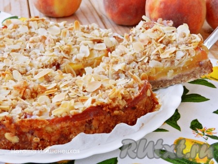 Очень вкусный, аппетитный, ароматный насыпной пирог из овсяных хлопьев и нежной начинкой из персиков нарезать на части и подать к столу.