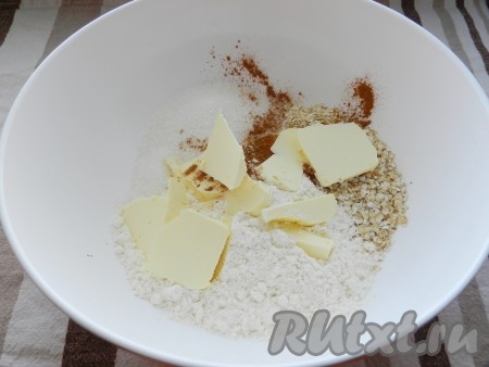 Добавить холодное сливочное масло, нарезанное на кубики, перетереть массу руками в крошку.