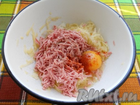 Натертую на крупной терке колбасу, яйцо, паприку, соль и перец добавить в картофельную массу.
