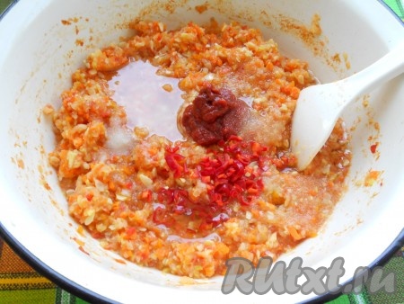 Смесь перемешать и поставить на огонь. После закипания варить овощи 20 минут, постоянно помешивая. Затем добавить соль, сахар, томатную пасту, мелко нарезанный горький перец (перец, в зависимости от того какую остроту аджики вы хотите получить, освободить от семян или использовать с семенами, в последнем случае - будет острее), влить растительное масло. Перемешать и варить на медленном огне еще 10 минут.&nbsp;
