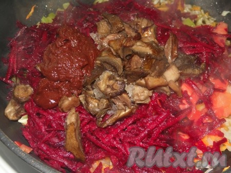 Грибы сварить до готовности, в течение минут 30, периодически снимая пену, отжать от лишней жидкости. Свеклу очистить и натереть на крупной тёрке.&nbsp; Добавить натёртую свеклу, грибы, томатную пасту, соль, пропущенный через пресс чеснок и специи на сковороду с морковью и луком. И томить под крышкой на маленьком огне минут 10-15.
