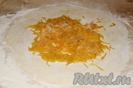 Каждую лепешку раскатываем в тонкий корж. Сверху выкладываем тертую на терке тыкву и посыпаем сахаром.