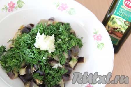 Переложить баклажаны в глубокую тарелку. Зелень вымыть, обсушить, мелко нарезать. Чеснок почистить и пропустить через пресс. Добавить в баклажаны зелень, чеснок и масло, тщательно перемешать.