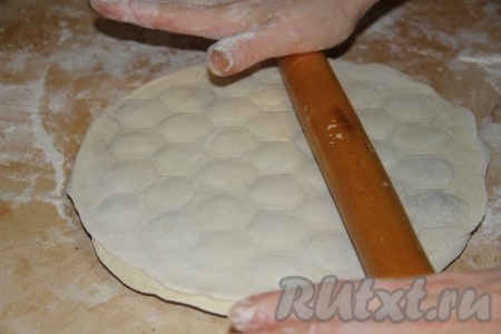 Сверху накрываем следующим раскатанным пластом теста и начинаем раскатывать тесто скалкой по пельменнице до тех пор, пока пельмени не начнут отделяться друг от друга.
