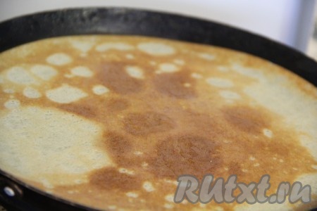 Перед выпечкой каждого блина необходимо перемешивать тесто в миске, чтобы оно имело одинаковую консистенцию. Я сковороду смазала маслом только один раз, перед выпечкой первого блина. Затем выпекала без добавления масла, но многое зависит от качества вашей блинной сковороды.
Выпекать блины на хорошо разогретой сковороде. На сковороду влить часть блинного теста, равномерно распределить и жарить блинчик на умеренном огне с двух сторон до румяности, затем переложить на тарелку. Блинчик получается тонким. Из оставшегося блинного теста постепенно испечь все блины.