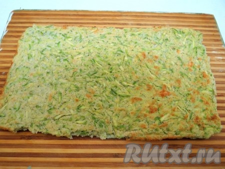 Готовый кабачковый корж вынимаем из духовки и охлаждаем на противне, затем перекладываем на доску и аккуратно снимаем бумагу для выпечки.