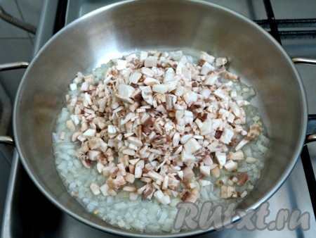 Когда лук станет прозрачным, добавляем к нему шампиньоны и обжариваем минут 7, иногда перемешивая. Затем к грибам с луком добавляем выдавленный через пресс чеснок, соль, чёрный молотый перец, перемешиваем и держим на плите на среднем огне до испарения жидкости (ещё, примерно, 3-4 минуты). Затем снимаем с огня и даём остыть.