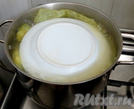 Сверху укладываем листья капусты и прикрываем небольшим грузом (у нас тарелка),&nbsp; заливаем посоленной водой, чтобы покрыла голубцы. Доводим воду до кипения, затем огонь убавляем до минимума и на самом маленьком огне томим 1 час и 30 минут.
